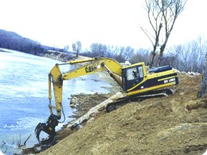 Excavadora destruyendo las orillas del río